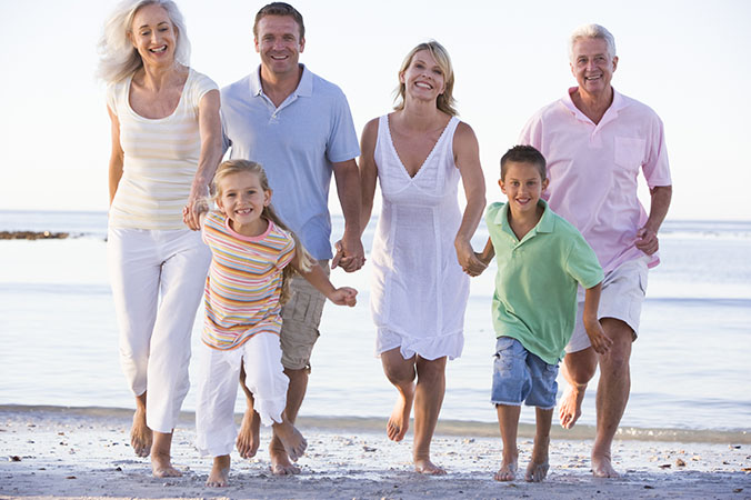 Extended family walking on beach