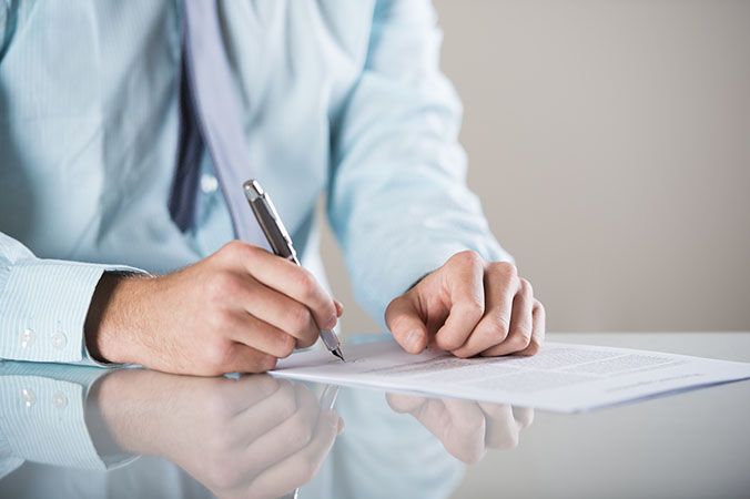 man signing a document